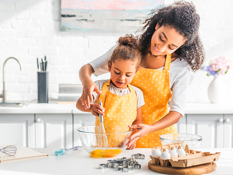 Cherish the Moments Together in an Amedore Home a woman and young girl cooking in their new home kitchen
